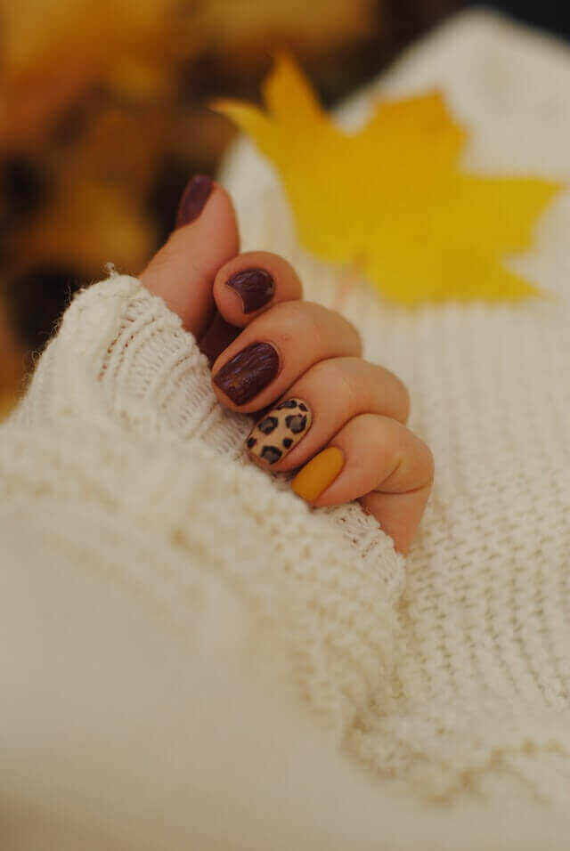 Hand with yellow and brown nail design