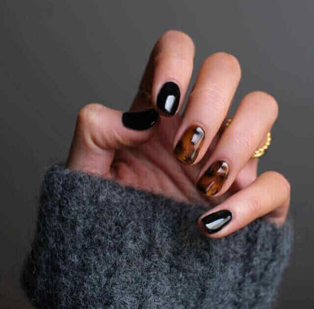 Hand with black and brown nail design